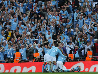Manchester City players and fans celebrate winning last year's FA Cup