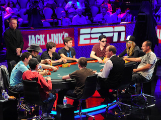 David Bach (cowboy hat) and Vanessa Rousso (baseball cap) and others at the main feature table on Day 4 (Photo credit: PokerNews / WSOP.com)