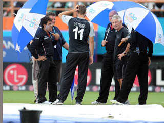 Daniel Vettori confers with the umpires during New Zealand's rain-affected win against Zimbabwe 