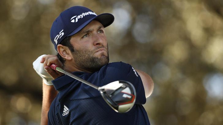 Golfer Jon Rahm watches his drive