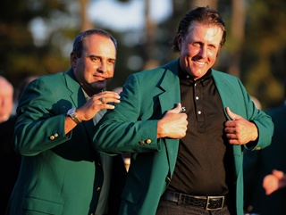 Angel Cabrera helps out Phil Mickelson with his third green jacket last year.