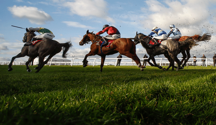 Horses jumping fence